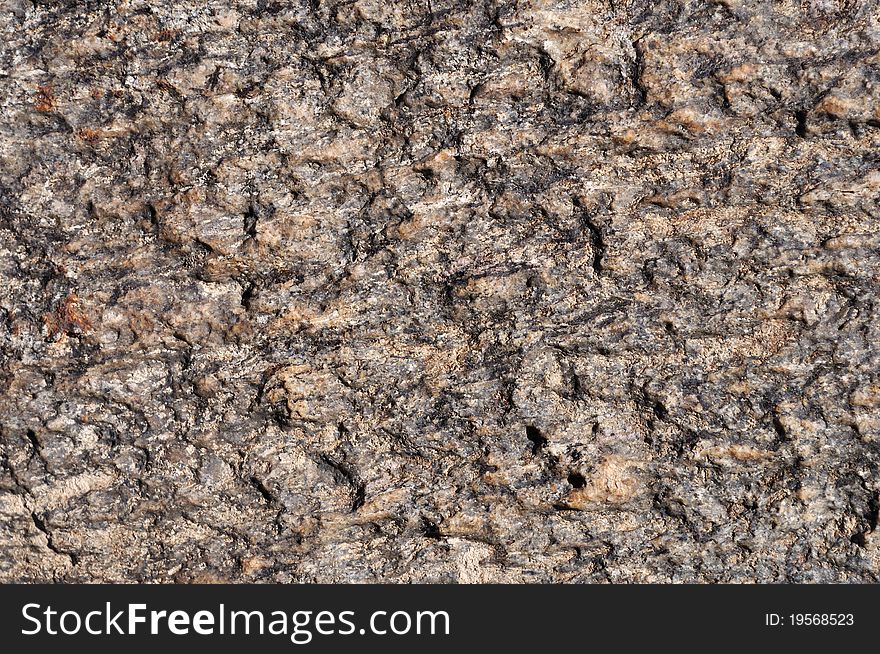 Fragment of natural brown stone surface texture. Fragment of natural brown stone surface texture