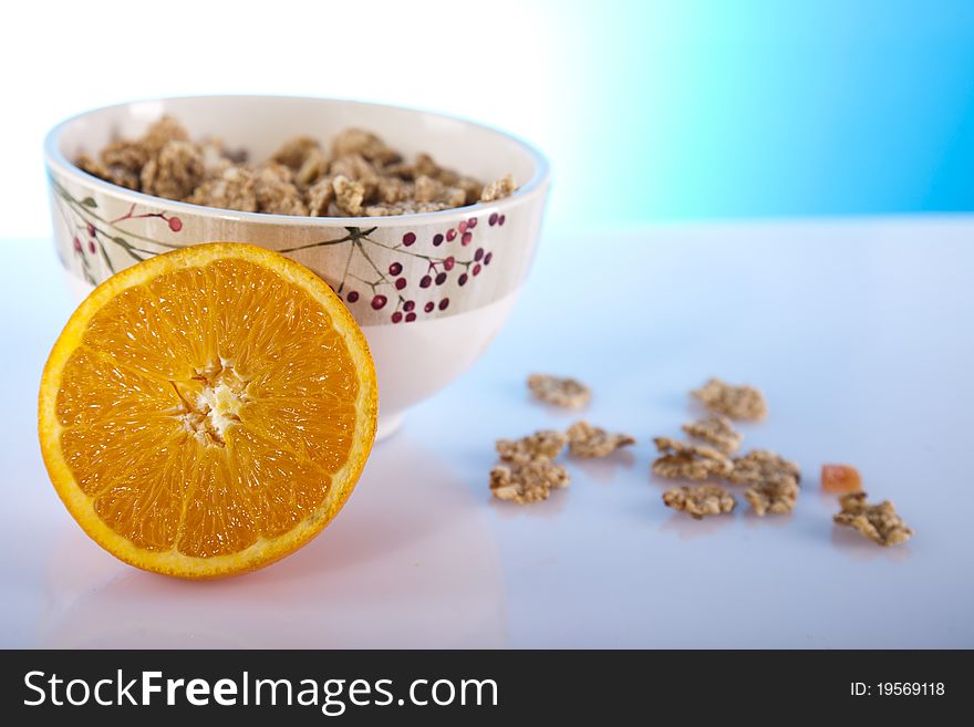 Cornflakes in a bowl and orange. Cornflakes in a bowl and orange