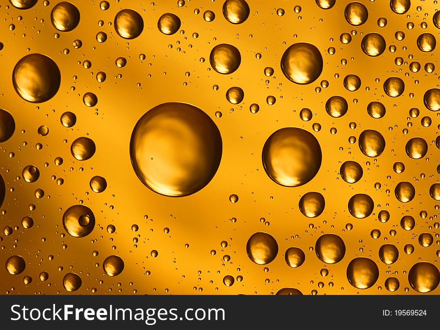 Yellow water drops on glass