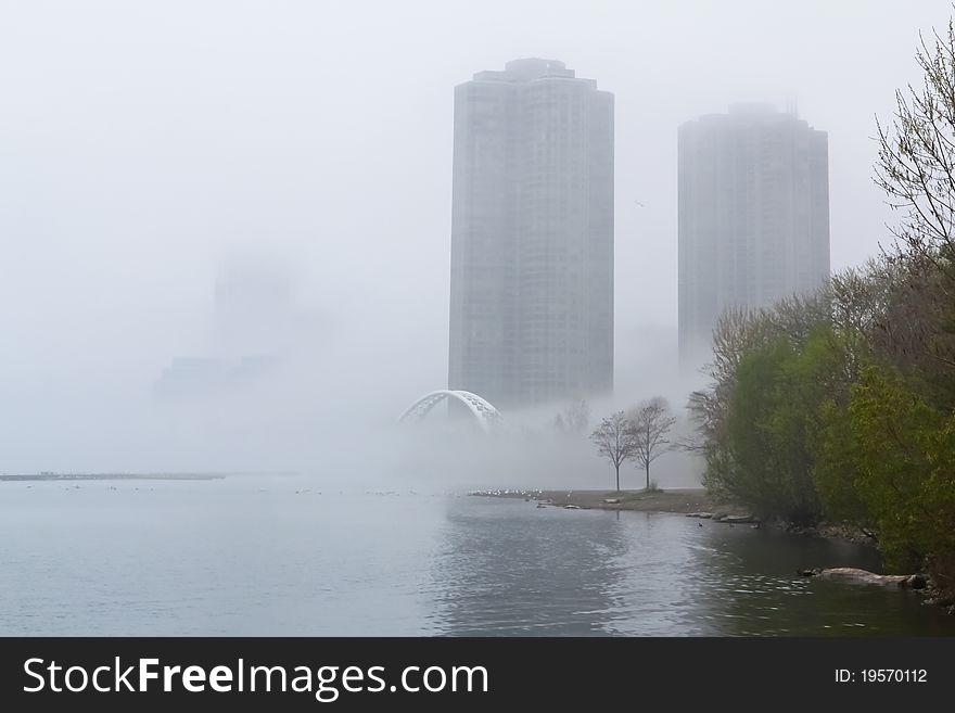 Long shot of condos and bridge in fog. Long shot of condos and bridge in fog