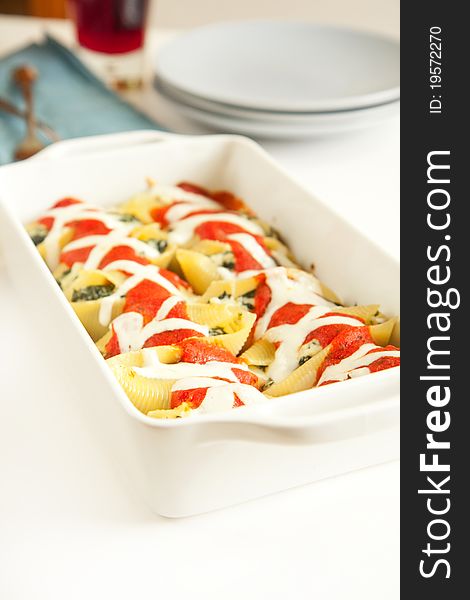 Stuffed pasta shells in white baking dish. Stuffed pasta shells in white baking dish