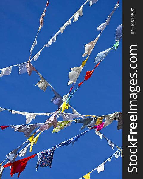 A group of colored shirts on a clothesline in front of blue sky