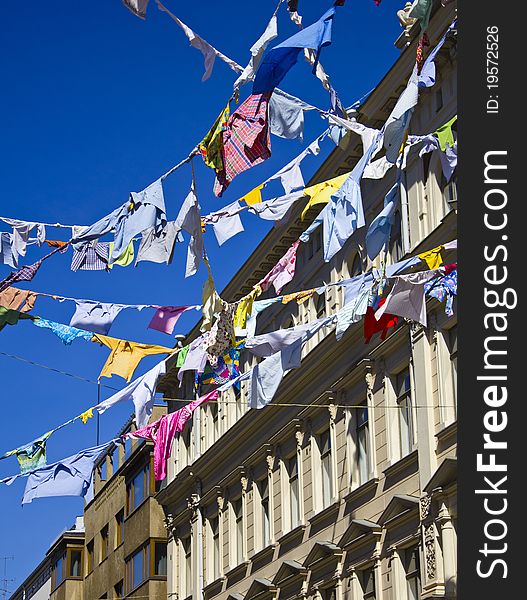 A group of colored shirts on a clothesline in front of blue sky. A group of colored shirts on a clothesline in front of blue sky