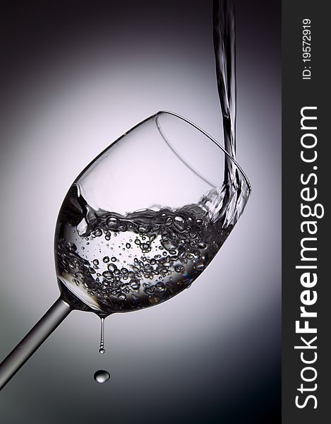 Filling a glass of water in white and dark background
