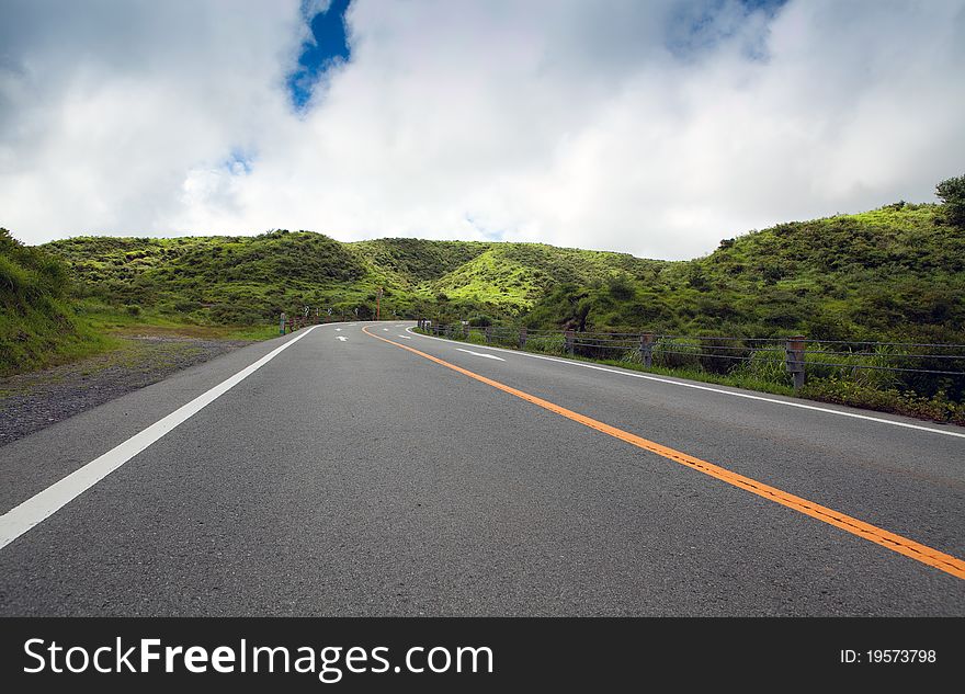 Asphalt road with a turn in the green hills. Asphalt road with a turn in the green hills.