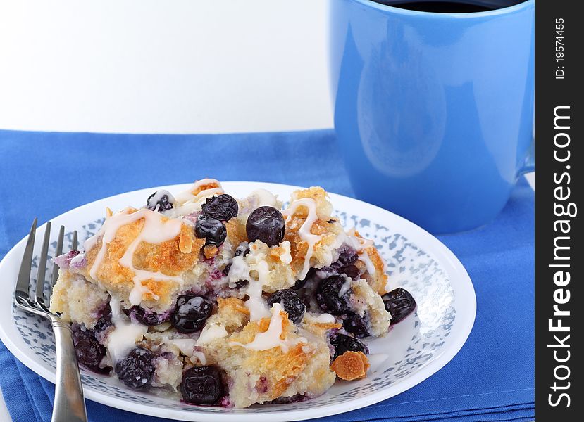 Plate of blueberry bread pudding with cup of coffee