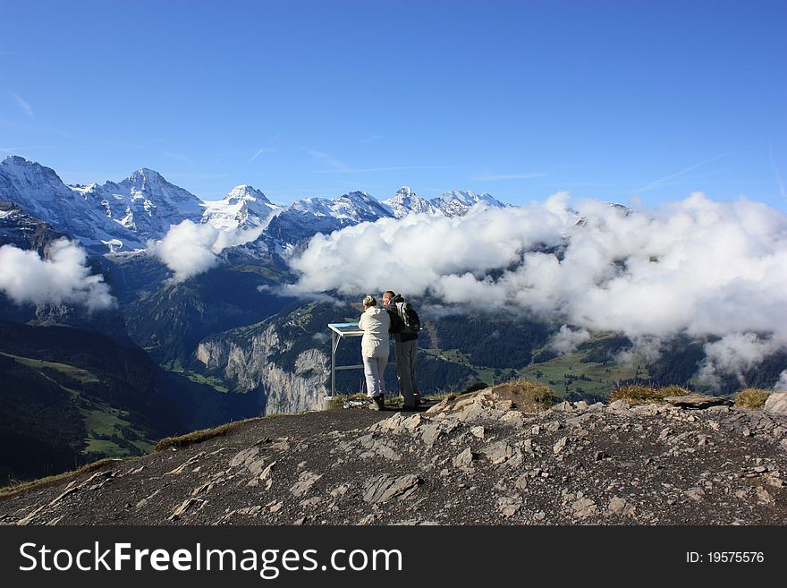 Two people viewing the mountain range in Switzerland. Two people viewing the mountain range in Switzerland