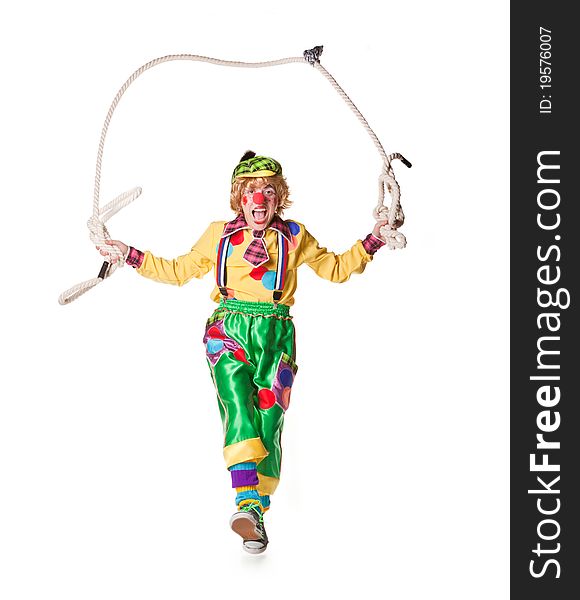 Cheerful clown jumps on a skipping rope isolated on a white background