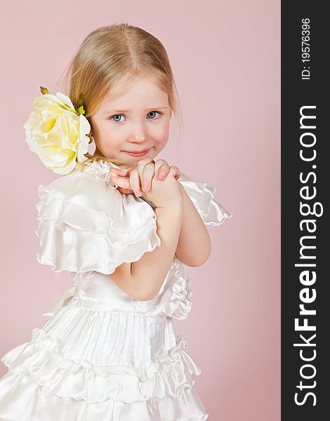 Child in a white dress with a flower in hair