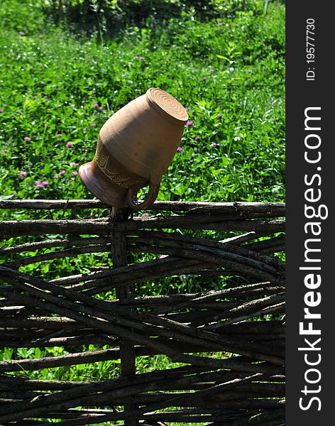 Image of a clay pitcher hanged on the fence