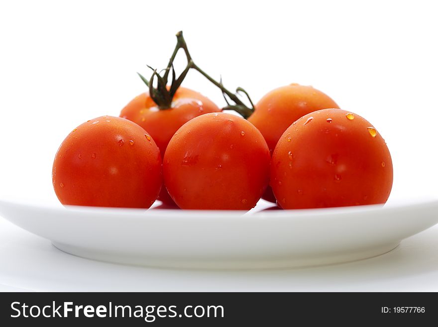 Macro of five tomatoes on a plate.
