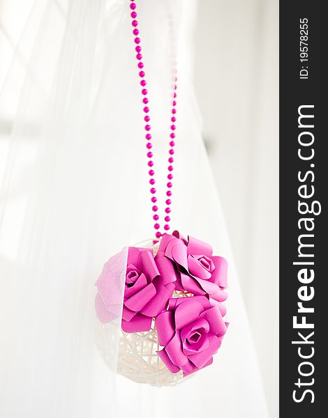 Bridal decoration of white sphere of bars with pink paper flowers and pink beads. Bridal decoration of white sphere of bars with pink paper flowers and pink beads