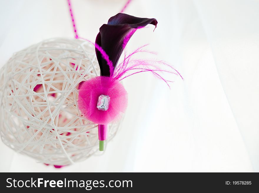 Bridal decoration of white sphere of bars with groom's pink boutonniere of black calla
