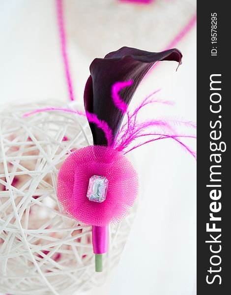 Bridal decoration of white sphere of bars with groom's pink boutonniere of black calla