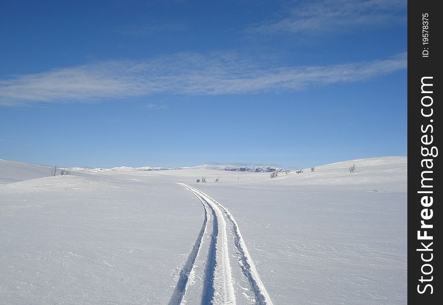 Tracks of a snowmobile in crisp snow i the mountains of Norway. Tracks of a snowmobile in crisp snow i the mountains of Norway