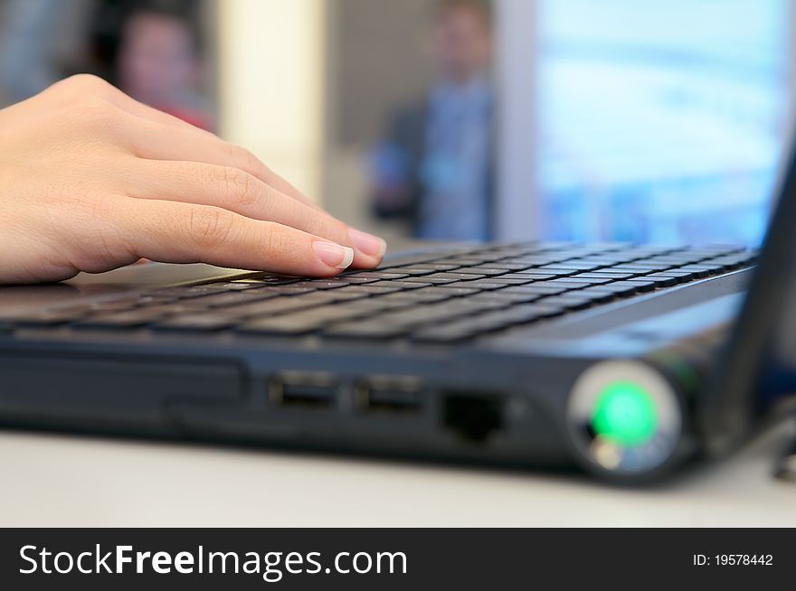 Woman's hand on the laptop keyboard.