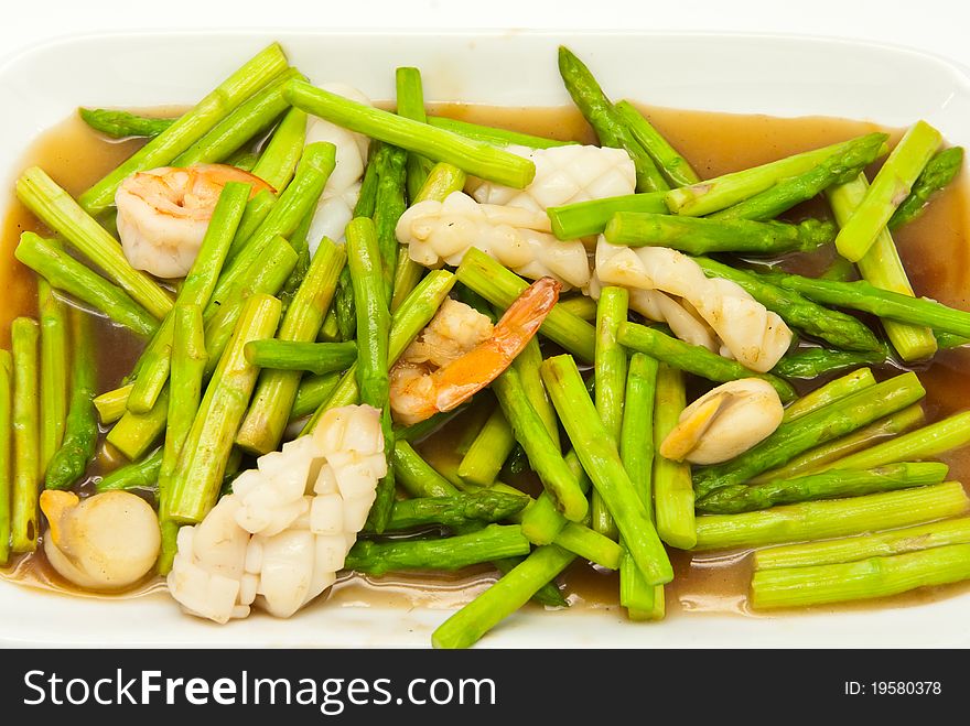 Fried asparagus with shrimp on the plate.