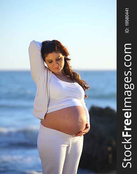 Pregnant woman at the Beach raised hand with belly open