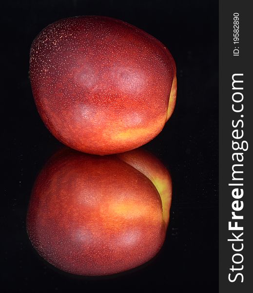 Nectarine and his reflection in the mirror on a black background