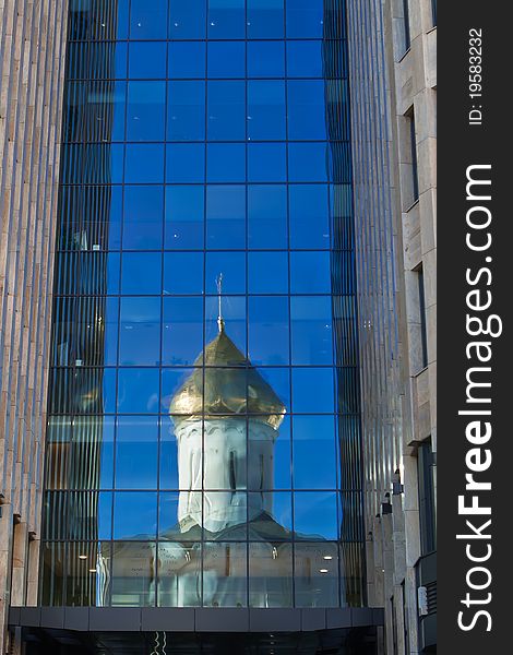 Old orthodox church reflected in a glass wall of new office building in the downtown of Moscow. Old orthodox church reflected in a glass wall of new office building in the downtown of Moscow