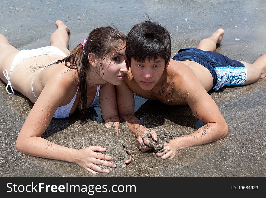 Young girl and asian boy on the ocean's beach. Young girl and asian boy on the ocean's beach