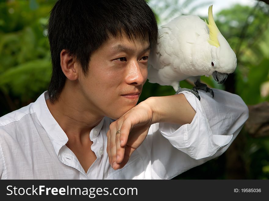 Young Asian man portrait with white  parrot. Young Asian man portrait with white  parrot