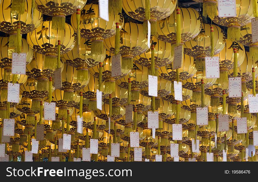 Rows of yellow chinese lanterns hanging from ceiling