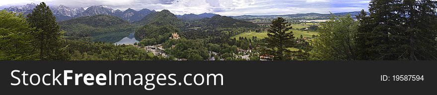 Panoramic view of Hohenschwangau Castle in the valley net to the lake and high peaks at the back in Germany