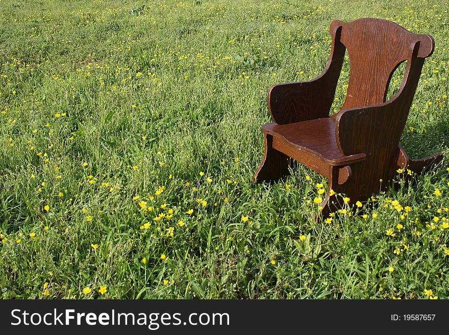 Brown children's rocking chair in peaceful meadow. Brown children's rocking chair in peaceful meadow.