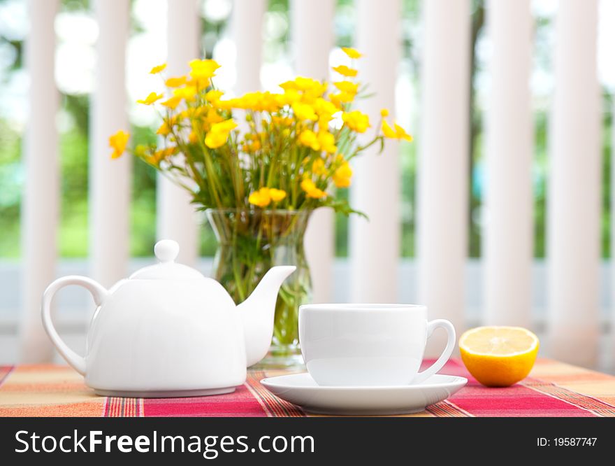 Cup of tea with teapot on table