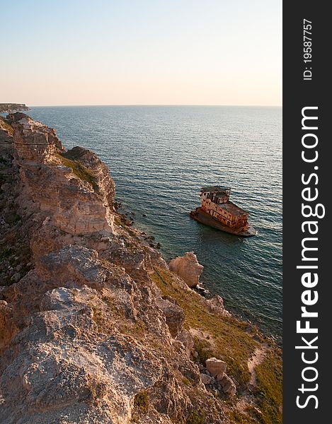 Sunken ship near the rocky shore