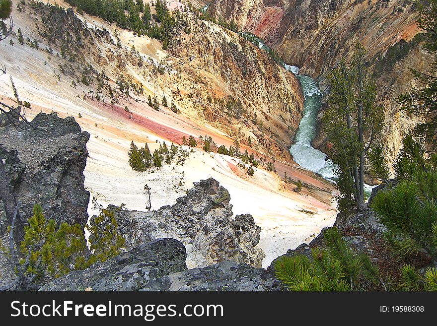 The Yellowstone River is surrounded by a beautiful and colorful canyon. The Yellowstone River is surrounded by a beautiful and colorful canyon.