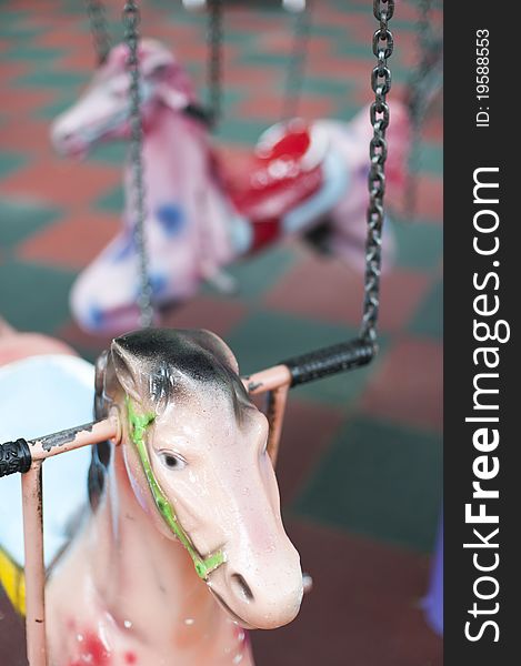 Pnk pony in a carousel in children's playground. Pnk pony in a carousel in children's playground