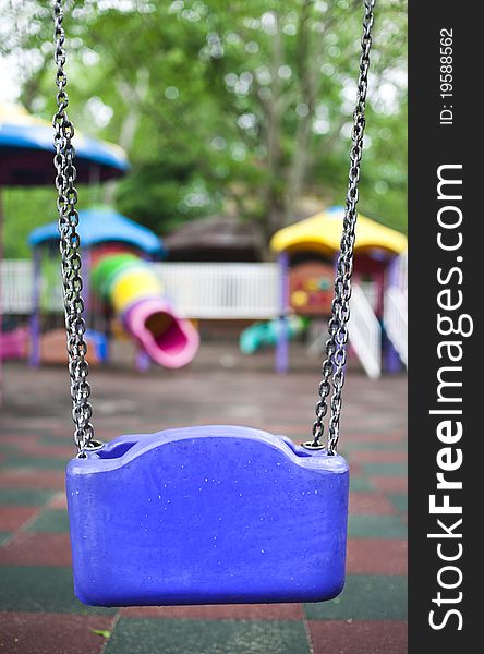 Back view of a blue child's swing in a playground. Back view of a blue child's swing in a playground