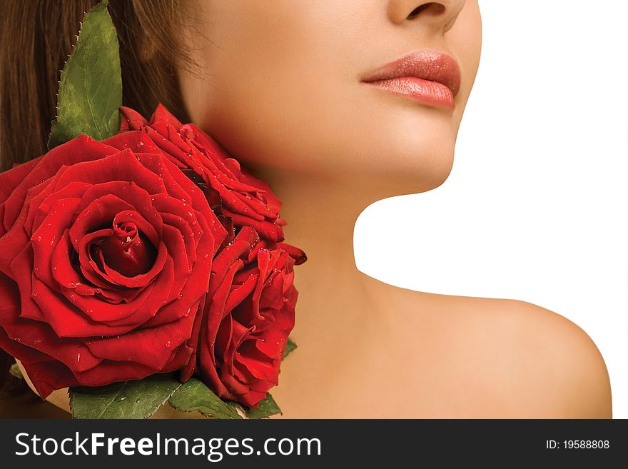 A studio view of the bare shoulder of a woman with three lightly colored roses. A studio view of the bare shoulder of a woman with three lightly colored roses