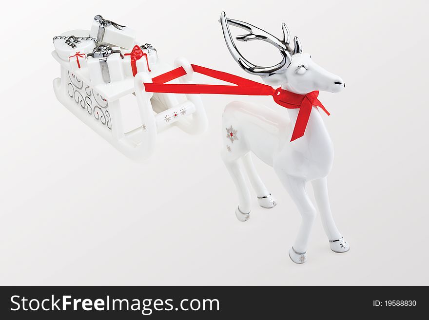 Figurine of reindeer pulling Santa's sleigh full of presents, against white background. Figurine of reindeer pulling Santa's sleigh full of presents, against white background