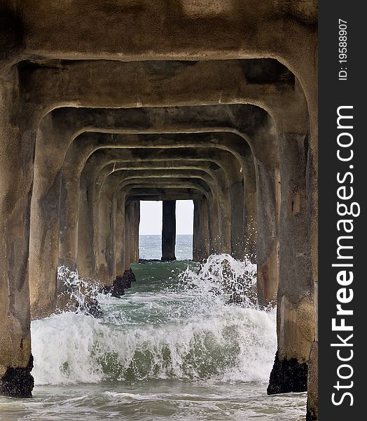 Waves coming on and crashing under the pier of manhattan beach,california