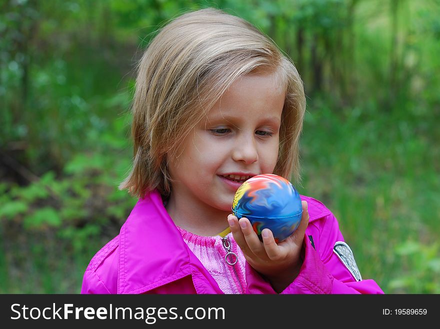 Portrait of european little girl with ball outdoors