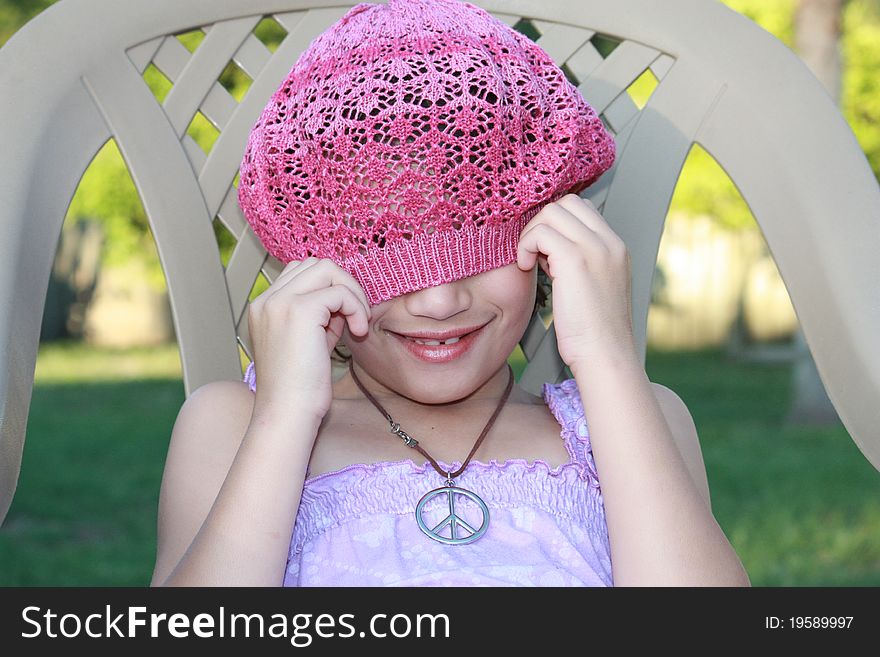 Playful girl with a peace sign necklace and a beret. Playful girl with a peace sign necklace and a beret