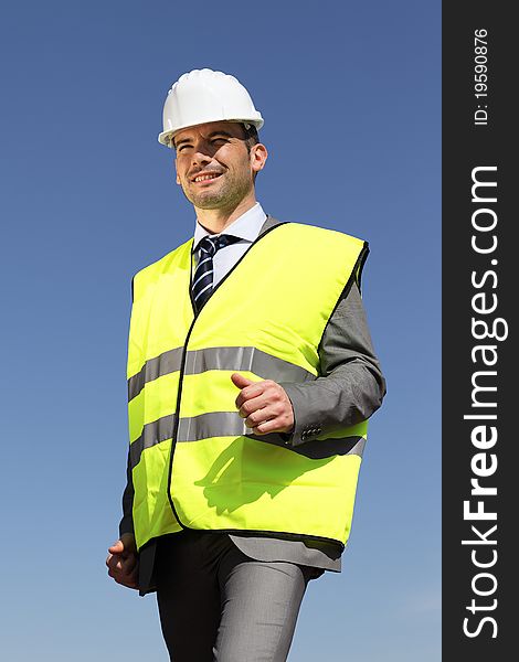 Young businessman with hardhat and blue sky