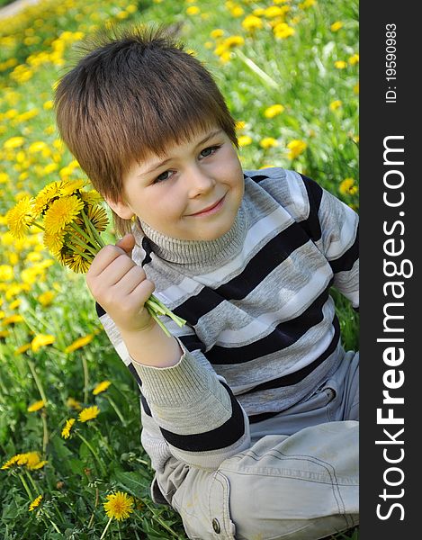 A Boy With A Bouquet Of Dandelions