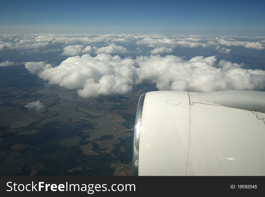 View of the turbine airplane, clouds and the Earth from the window