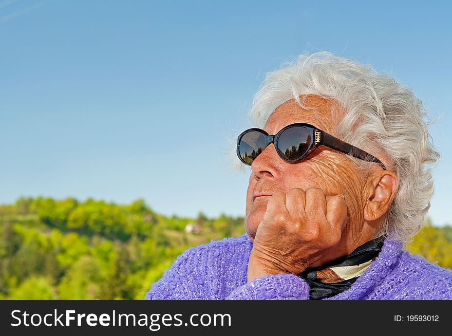 Senior woman is dreaming, picture taken during the sunny day.