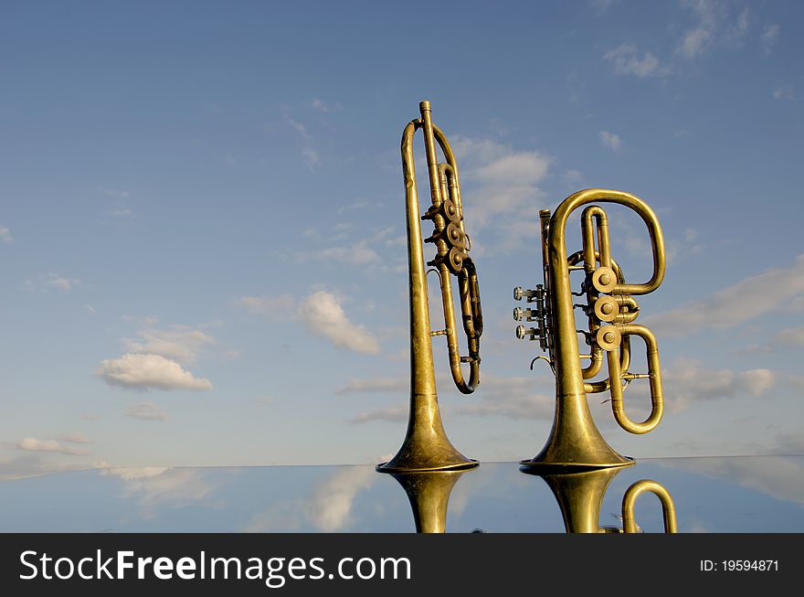 Two musical wind instrument on mirror and sky. Two musical wind instrument on mirror and sky