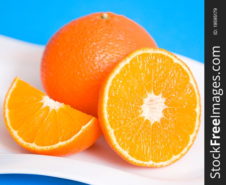 Fresh oranges on a white plate