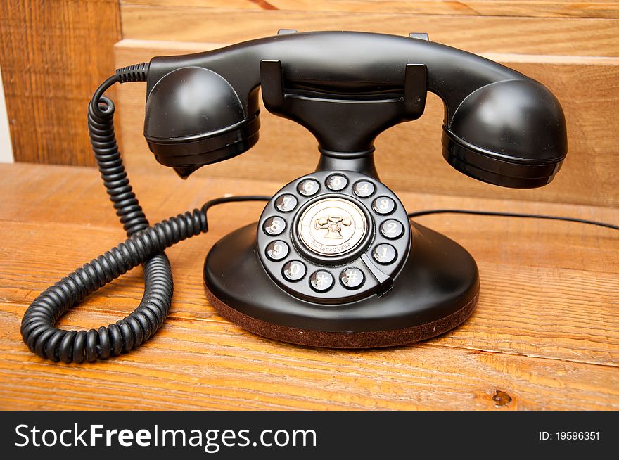 Black antique phone on wooden table