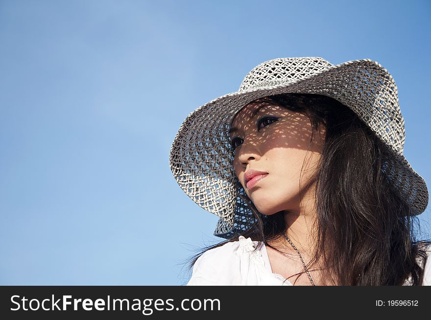 Young beautiful woman wearing a hat isolated over blue background