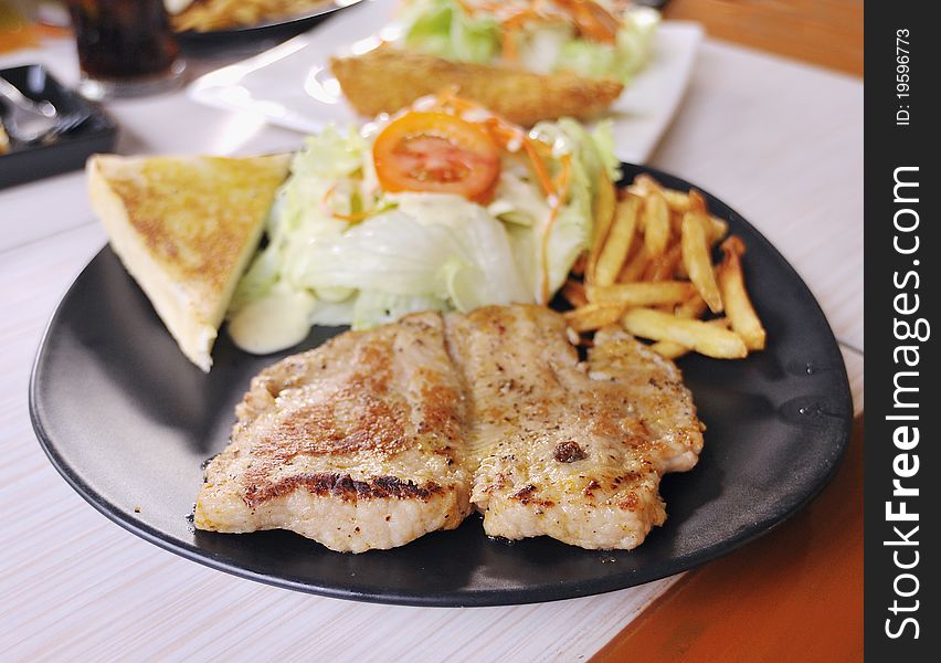 Fried pork steak with onion on the plate,shallow focus