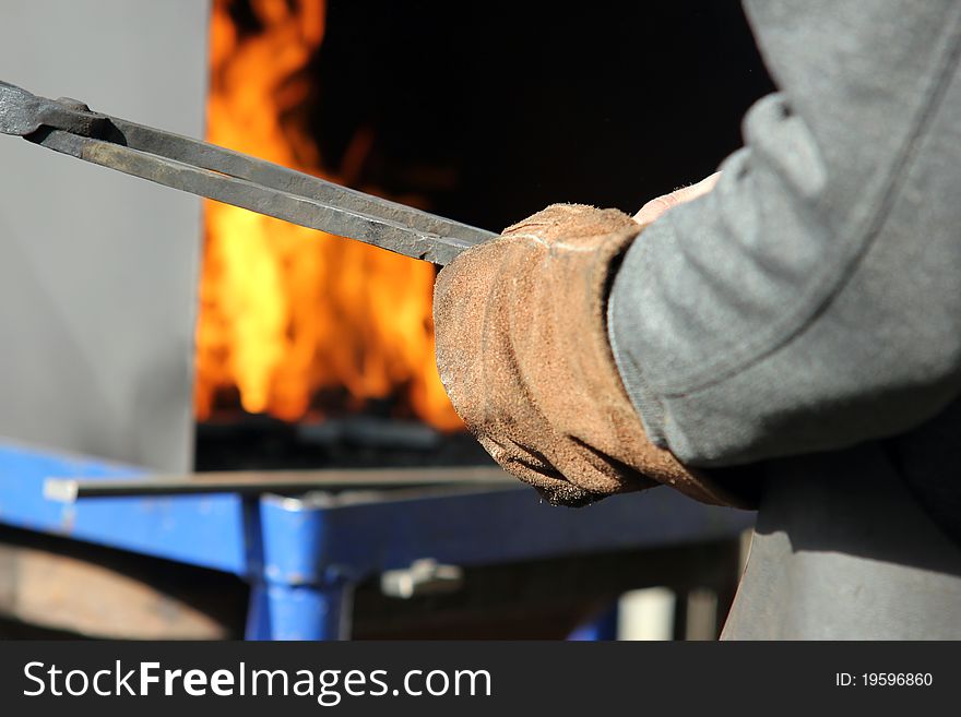 A blacksmith at work with red-hot iron. A blacksmith at work with red-hot iron.