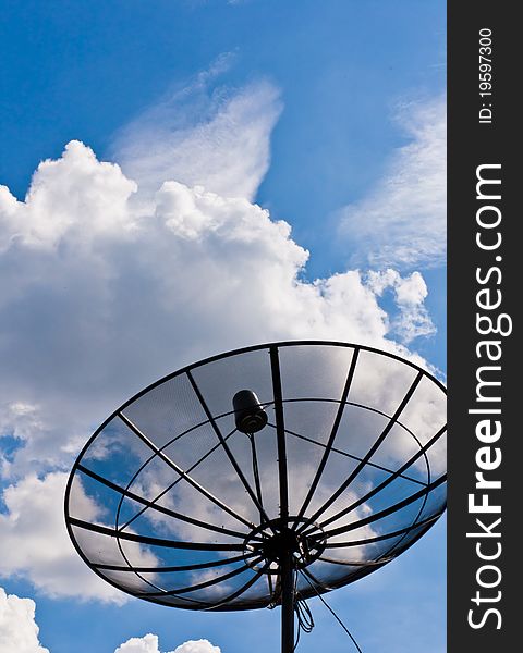 Satellite dishes under a black sky and fluffy clouds. Satellite dishes under a black sky and fluffy clouds